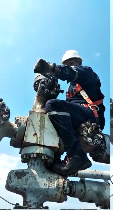 Técnico trabajando en altura sobre un cabezal de pozo